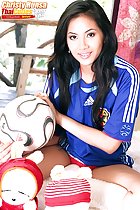 Sitting cross legged holding ball wearing Japan football shirt
