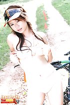Leaning against bike raising her top in panties