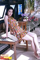 Leaning back on bench wearing dress legs crossed in high heels