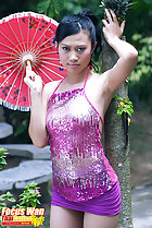 Standing beside tree holding parasol